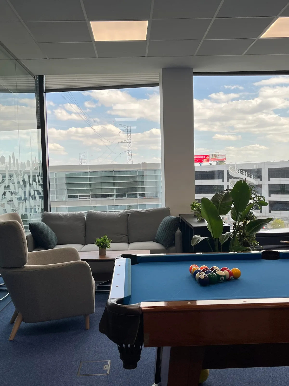Sala común de la oficina de Capital Appraisal — zona de descanso con sofás y vistas exteriores.